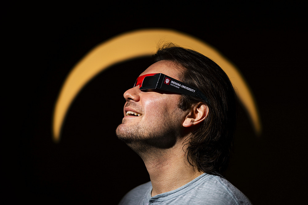 Anthony Magaldi poses for a portrait wearing IU South Bend Eclipse Glasses Thursday, Feb. 22, 2024, on campus at IU South Bend. (Photo by Mi