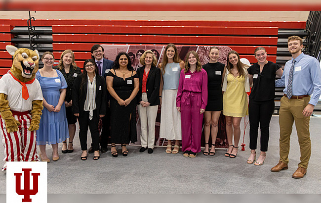 A group photo in front of a red background