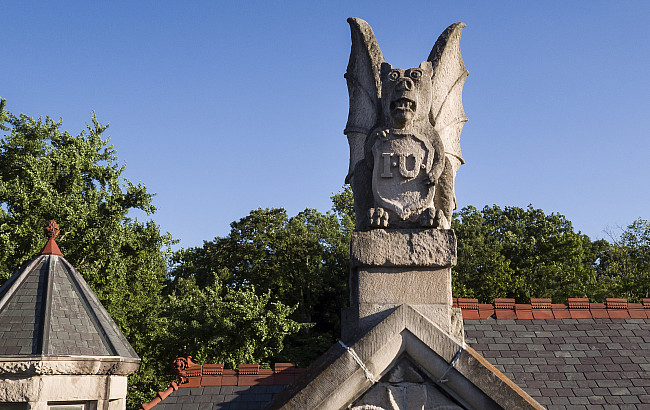 A limestone grotesque sits atop Maxwell Hall on the Indiana University Bloomington campus on Tuesday, June 5, 2018.