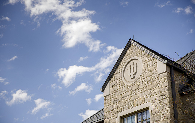 A limestone trident adorns the side of the Hutton Honors College on a spring day at Indiana University Bloomington.