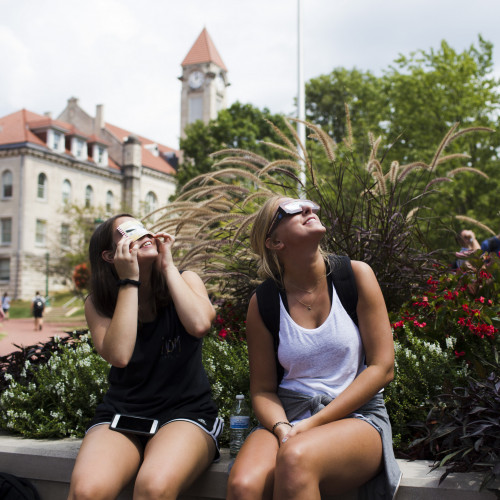 Students look up at the solar eclipse while wearing eclipse glasses.