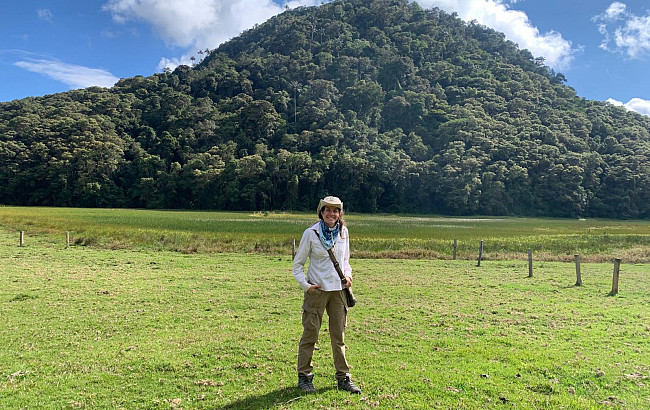A woman in front of a volcano
