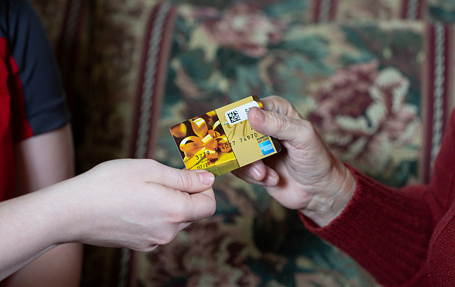 Two hands holding a credit card.