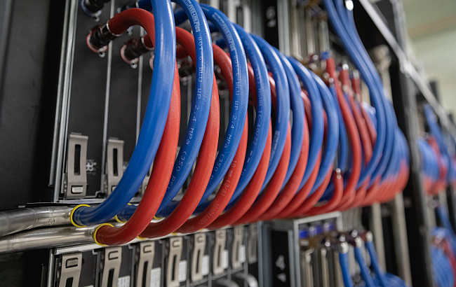A close up of blue and red wires in a server rack