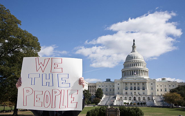 A protestor holding a placard in front of the US Capitol Building