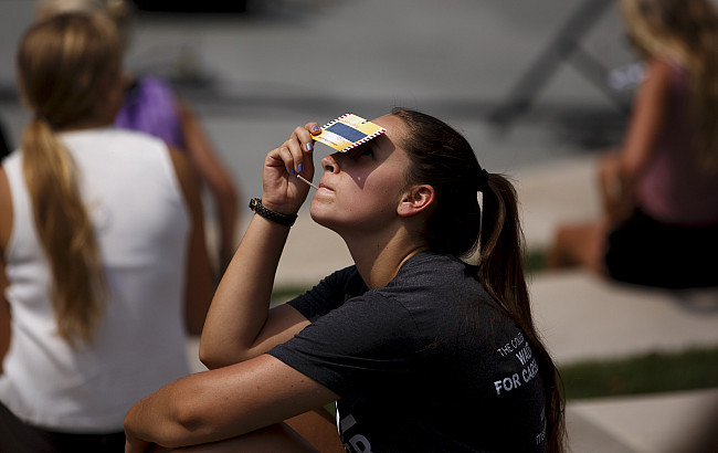 A student watches the solar eclipse during a viewing party at the Conrad Prebys Amphitheater at Indiana University Bloomington on Monday,...