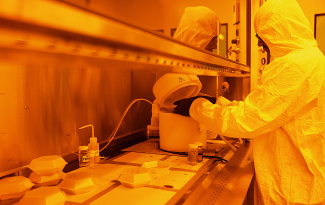 A student works in a hazmat suit in a lab