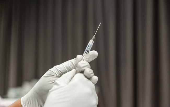 Hands on a syringe