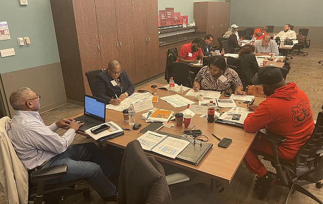 People work around a table during a program at the Kelley School.