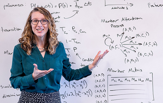 Jennifer Trueblood stands in front of data written on a whiteboard
