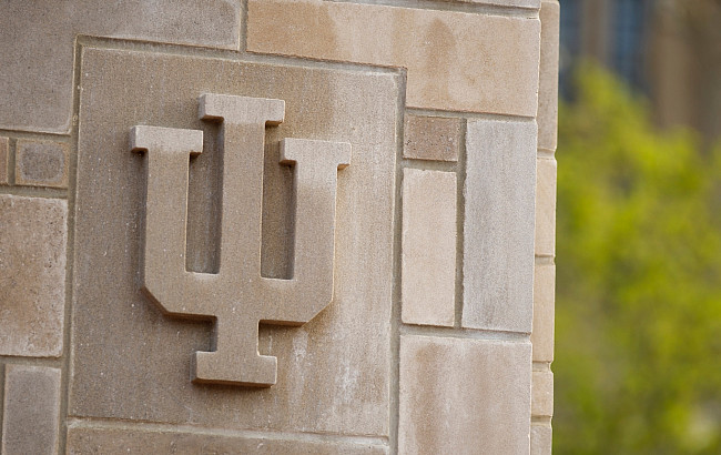 An IU trident adorns a limestone gate outside the Indiana Memorial Union