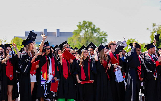 A group of students in caps and gowns outdoors.