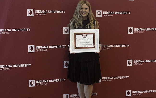 woman in dress holding certificate