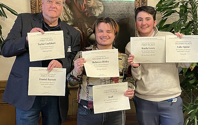 three men pose with award certificates