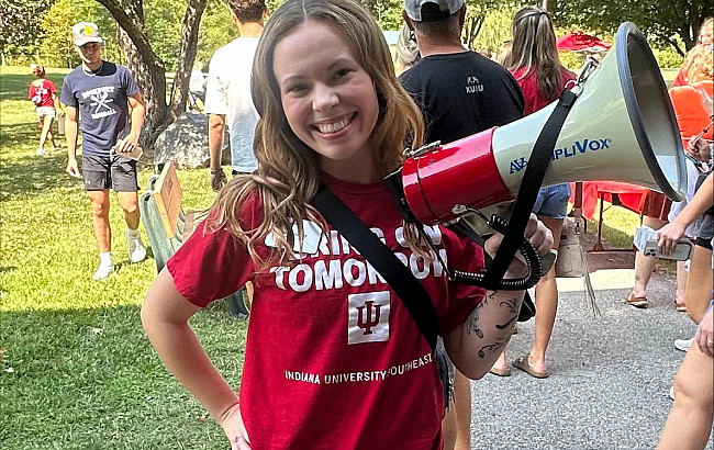 woman in red shirt holding a bullhorn