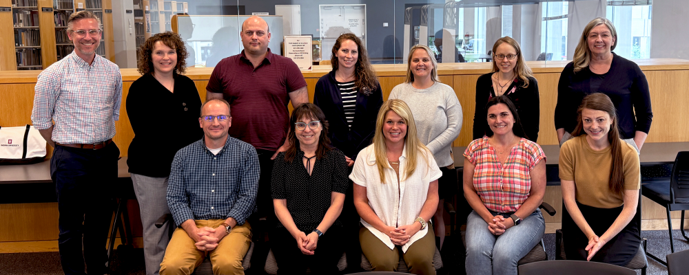 Photo caption: Learning Analytics Faculty Fellows at launch of the Initiative.    Alt Text: Group of smiling faculty who make up the UITS...
