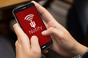 Hands holding a cell phone that reads 'IU Notify'