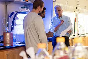 Richard DiMarchi, right, chats with two colleagues in a lab