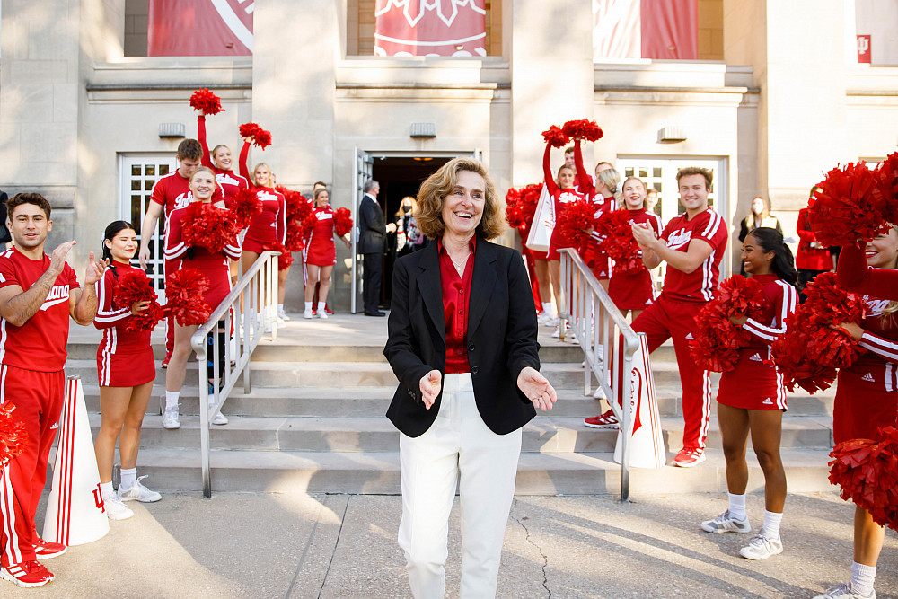 Indiana University President Pamela Whitten reacts as she emerges from the IU Auditorium and hears the IU Marching Hundred performing nea...