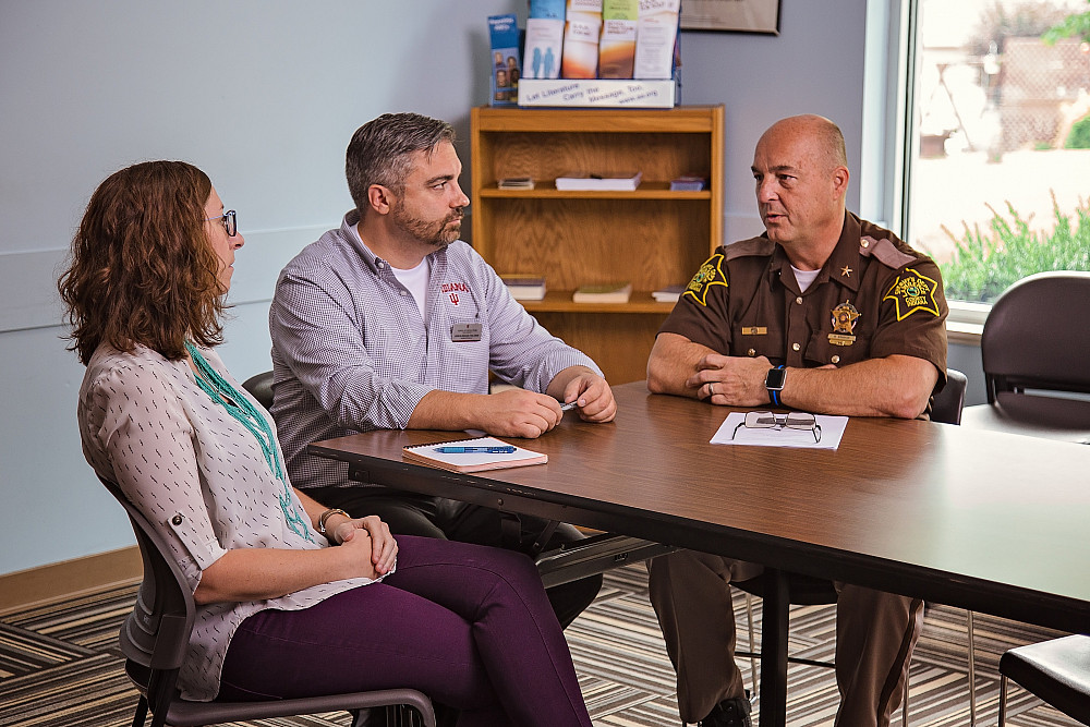 John Keesler, middle, and a community mental health professional talk with then-Lawrence County Sheriff Mike Branham as part of the Susta...