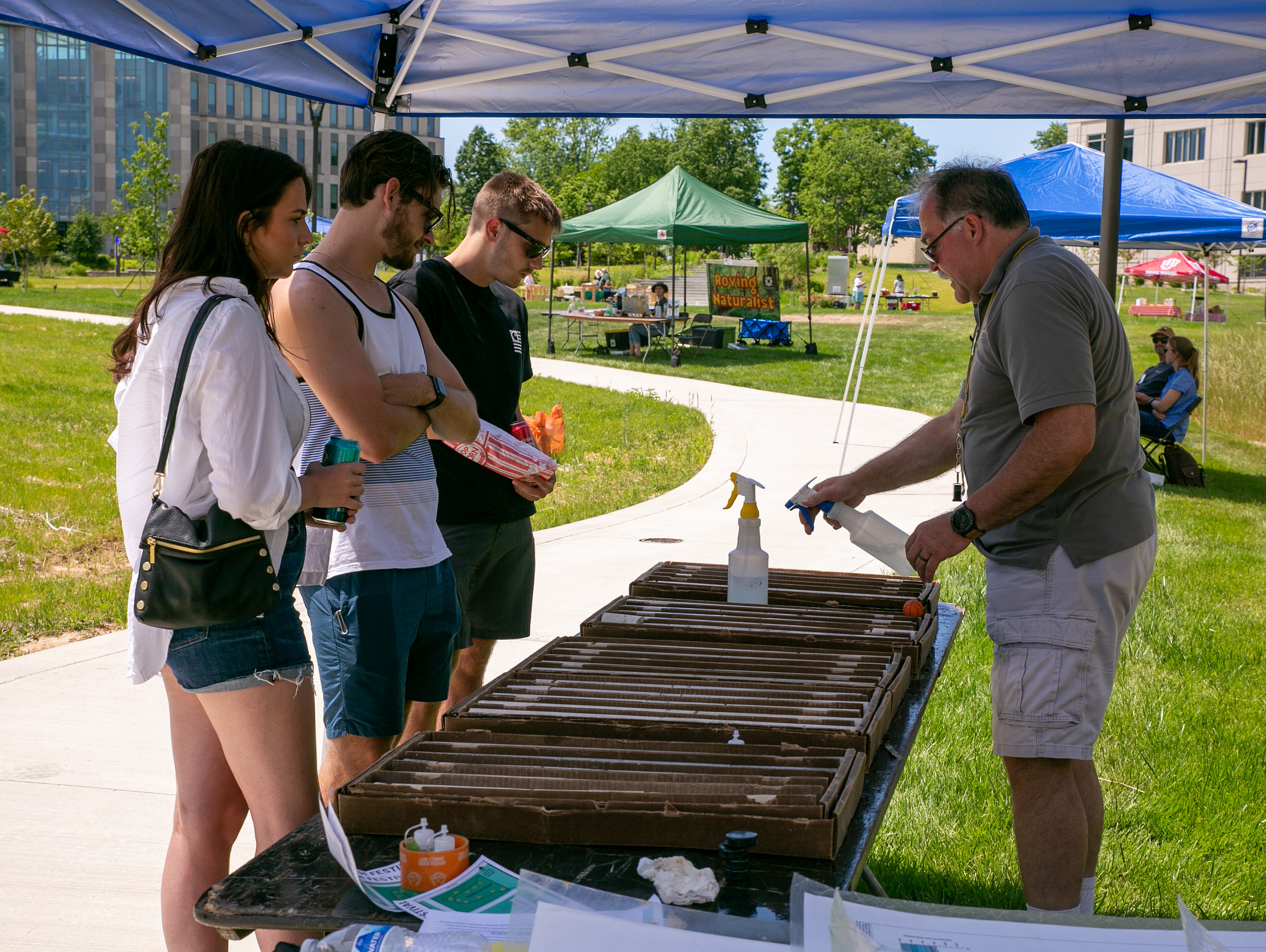 Three people gathered around a display table at Limestone Fest
