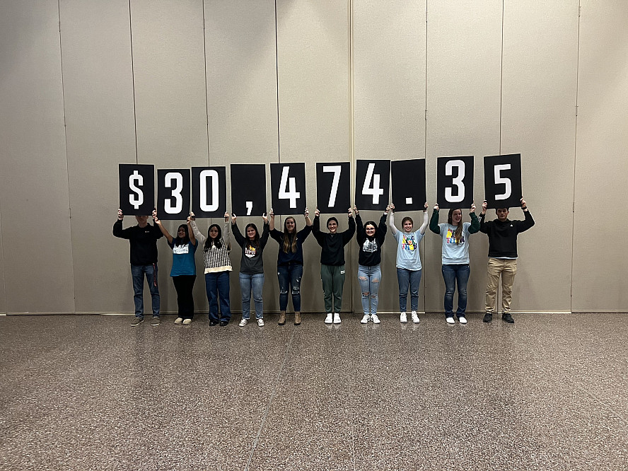 Jagathon members holding up the numbers displaying the total amount fundraised during 2024's Marathon to Miracles during the reveal on th...