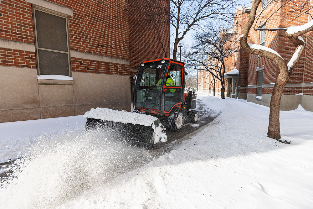 A CFS employee clears the sidewalk at Riverwalk Apartments at IUPUI on Friday, Feb. 4, 2022.