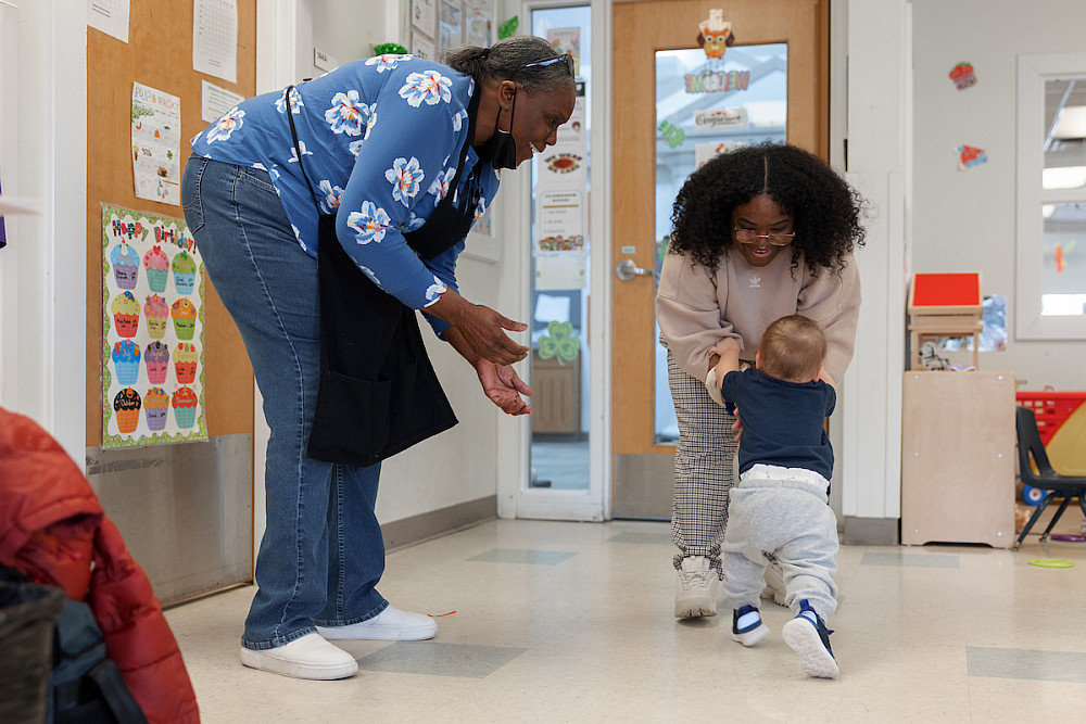 A child walks to Madison Colby, a classroom assistant, as Crawford looks on. Photo by Liz Kaye, Indiana University