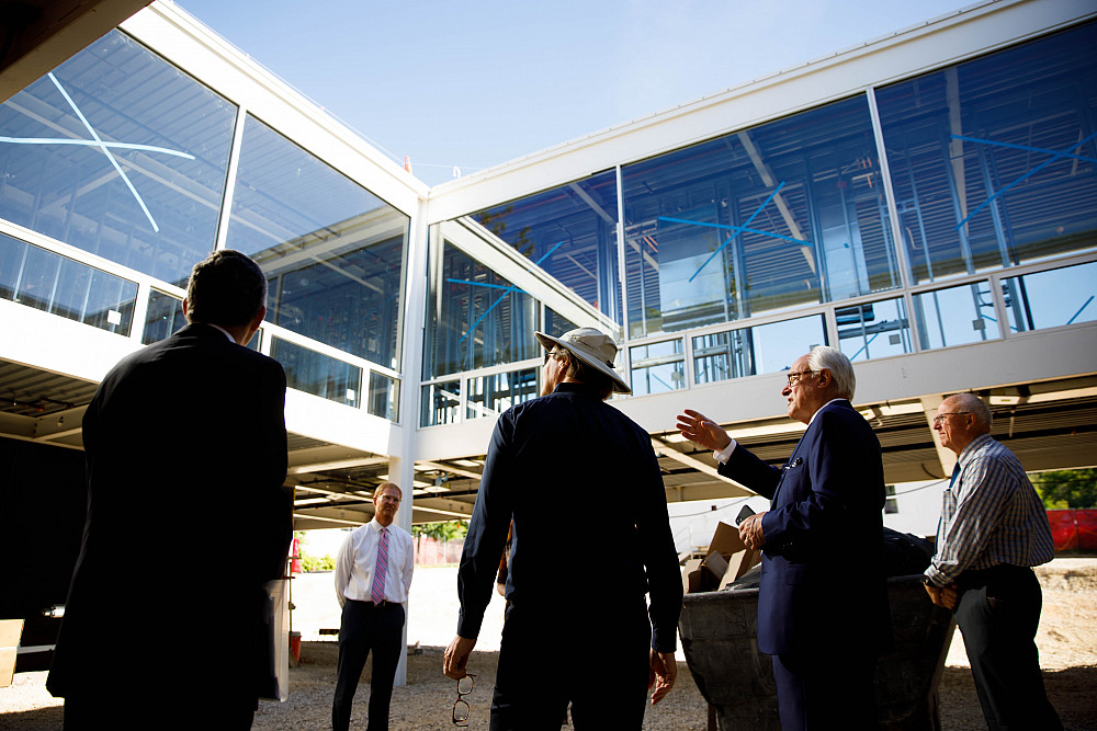 Architect Dirk Lohan, second from right, gestures as he tours the courtyard of a building designed originally by his grandfather, archite...