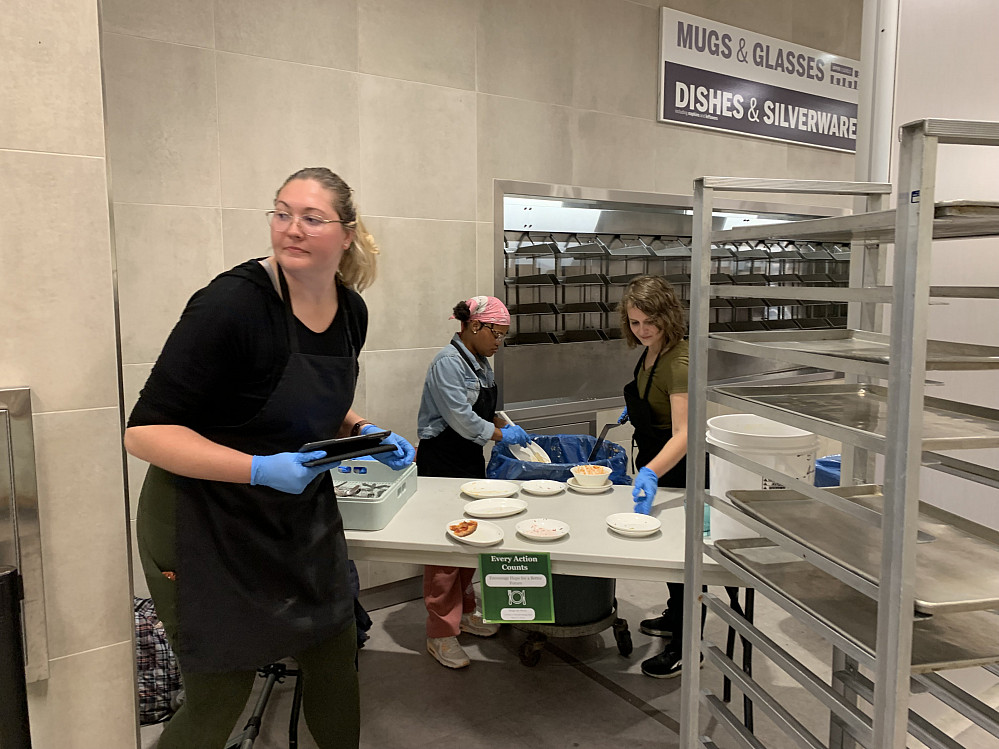 Project volunteers Anitra Higgins, Erin Hosein, and Elissa Booras empty food waste into containers. Photo by Kaeley Geschke