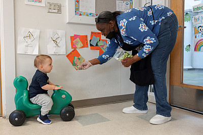 Karen Crawford, a teacher at the Center for Young Children at IUPUI, hands a child a snack. Photo by Liz Kaye, Indiana University 