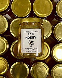 Jar of honey with label facing up sitting on top of multiple jars.