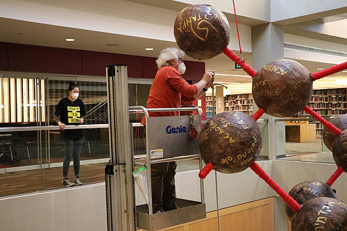 Herron School of Art and Design interim dean Greg Hull helped install the sculpture by Xiaoman Joy Gu (left) in the IUPUI University Libr...