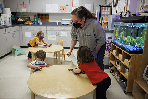 With the assistance of some toddlers, teacher Samantha Sisk cleans up after a classroom art project involving paint, glue and pumpkins at...