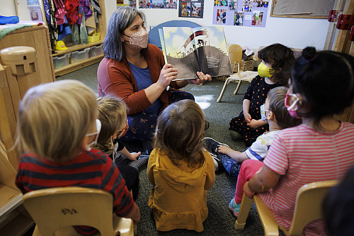 Teacher Jennifer Addleman reads The Day the Babies Crawled Away to an attentive group of toddlers at the Campus View Child Care Center at...