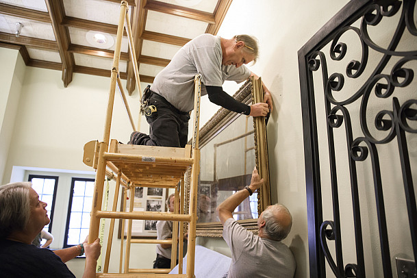 John Walker mounts a painting to the wall of the Memorial Room at the Indiana Memorial Union as Indiana University Bloomington Curator of...