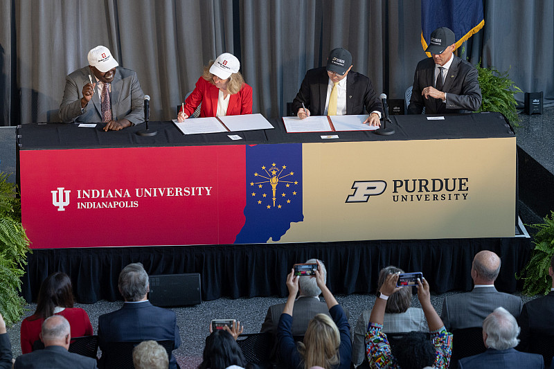 IU President Pamela Whitten and Purdue President Mung Chiang sign the definitive agreement. Photo by Chris Meyer, Indiana University