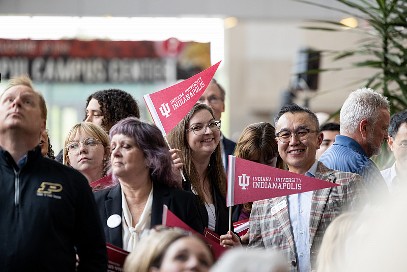 Attendees wave IU Indianapolis pennants during the signing ceremony. Photo by Liz Kaye, Indiana University