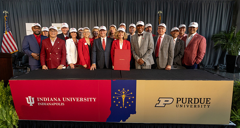 IU President Pamela Whitten, Board of Trustees members and other campus leaders celebrate after the signing ceremony. Photo by Liz Kaye, ...