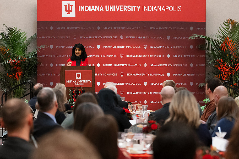 Chancellor Latha Ramchand speaking from behind a podium