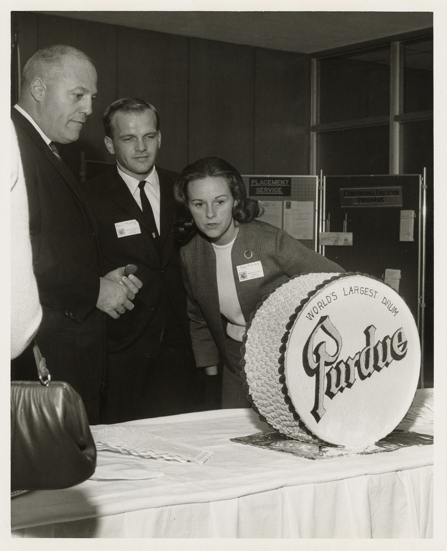 People admire a cake in the shape of a drum at Purdue-Indianapolis Extension reception, September 6, 1967