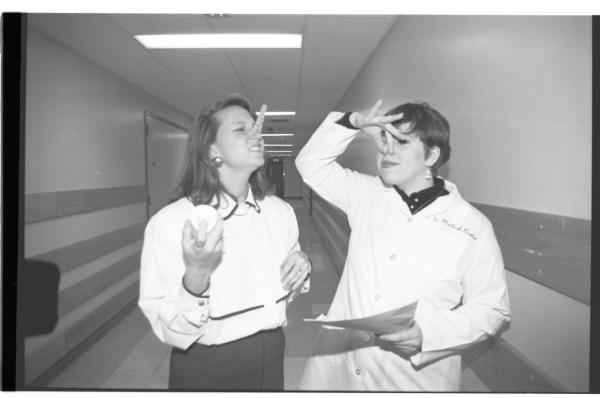 Photo from 1993 of two people plugging their noses