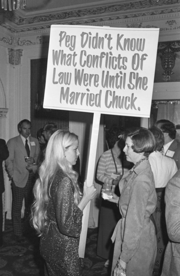 Woman carrying placard at School of Law cocktail party 1976